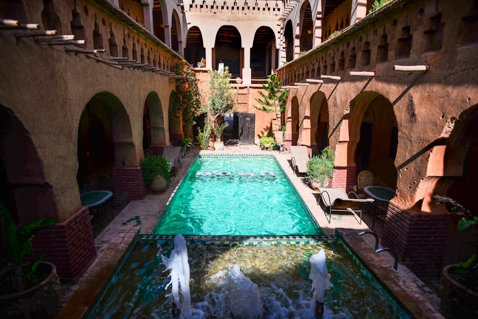 Beautiful courtyard with a central pool and historic architectural elements under daylight.